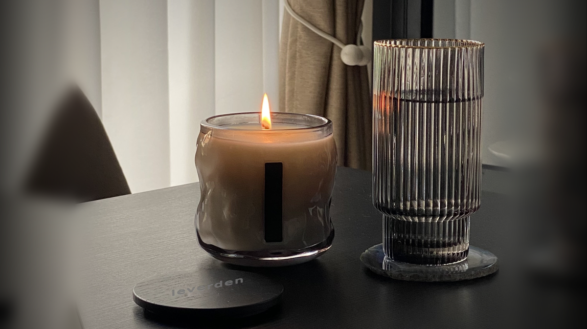 The Night Ritual: a lit leverden candle on a dark desk at dusk